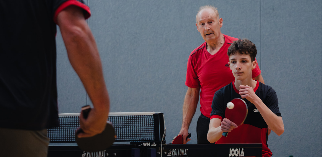 Ein junger Tischtennisspieler macht einen Aufschlag.
